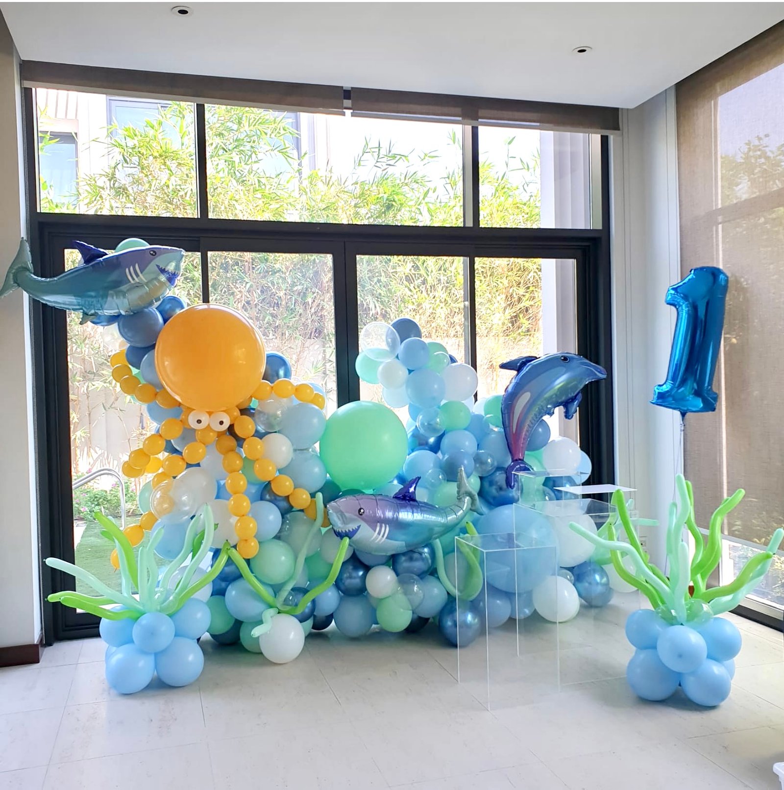 Under the sea (Mini balloon wall with octopus(golden rod and 3 fishes (foils) approx. 1.5m high  3 x sea weeds 1 x Medium and 1 x large acrylic table personalization on the balloons Number 1 foil balloon)